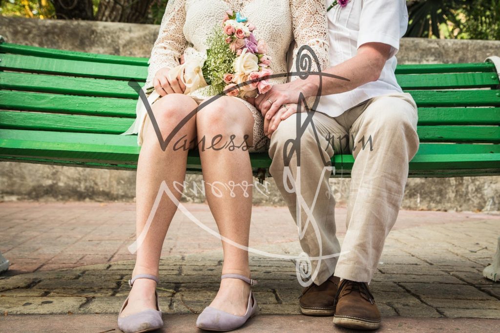 Newlyweds Side-by-Side on a Bench